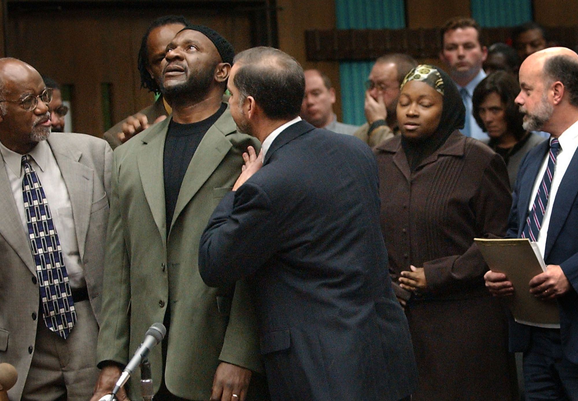 Hunt with lawyers Mark Rabil (r) and James Ferguson, reacts to a judge dropping murder charges against him at a hearing in 2004. (Ted Richardson/Winston-Salem Journal)